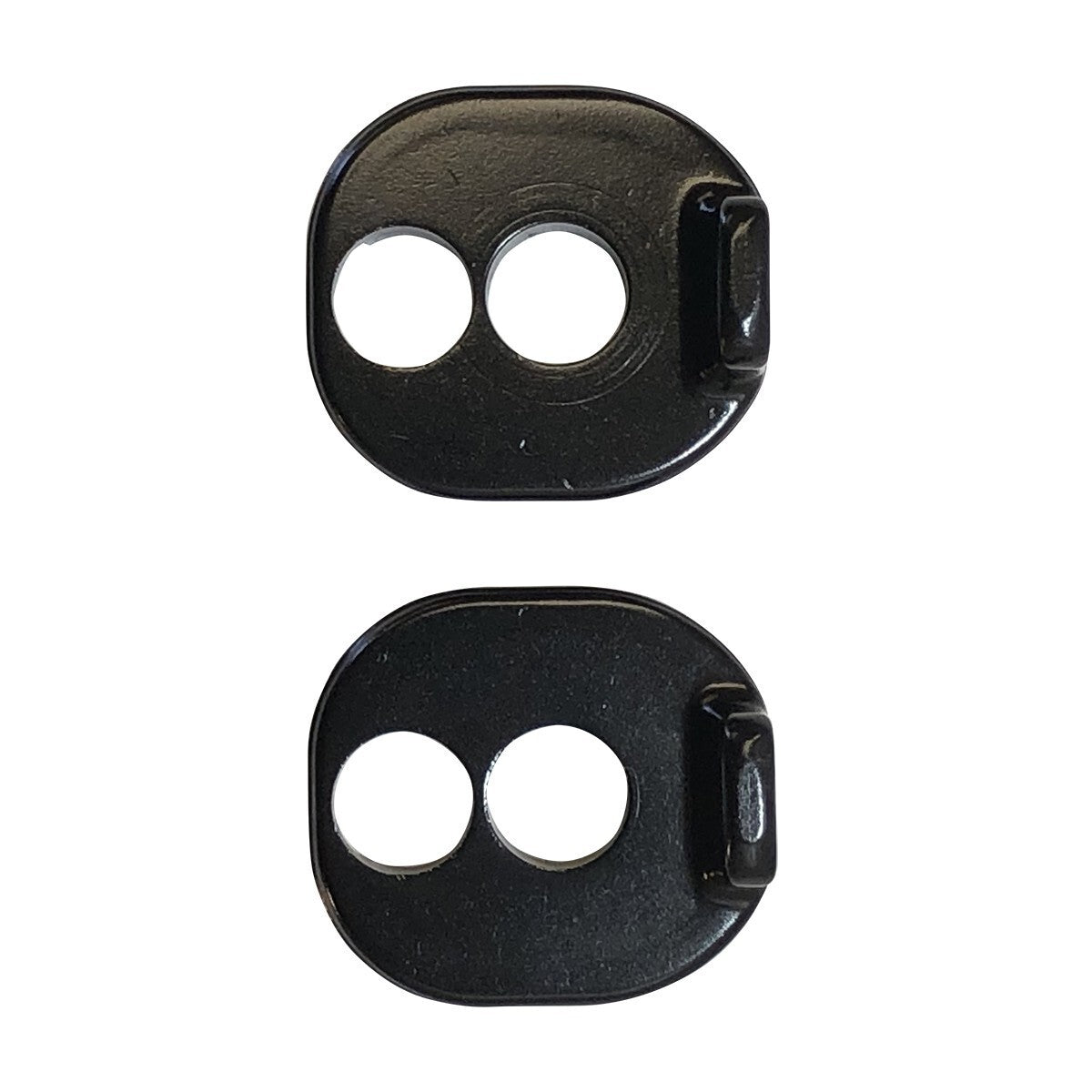 Two black Chain Tensioner Kit for ACT Frame metal plates, each featuring two circular holes and a raised edge on one side, are displayed vertically against a white background. These blocks are compatible with ACT 1.2 frames and come in either 10mm or 20mm sizes.