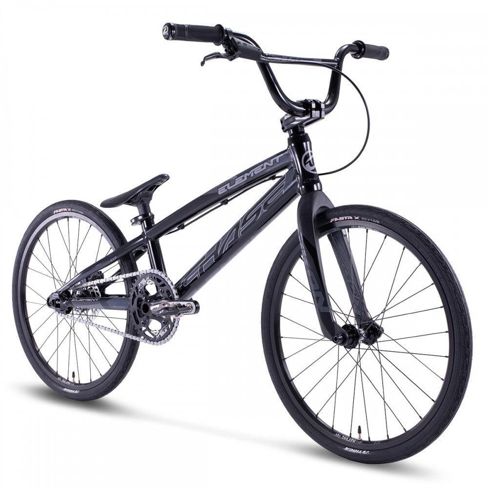 The Chase Element Expert Bike boasts a sleek black BMX design, featuring a silver chainring, black handlebars, and black tires with white text on the rims. The Expert XL frame pairs perfectly with Ikon carbon forks for an unparalleled riding experience.
