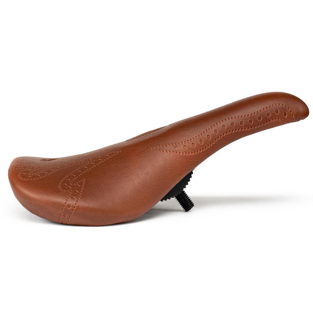 Eclat Exile Pivotal Seat / Tyson: Brown leather BMX seat with decorative stitching, shown in profile on a white background. Inspired by the original Eclat Exile design.