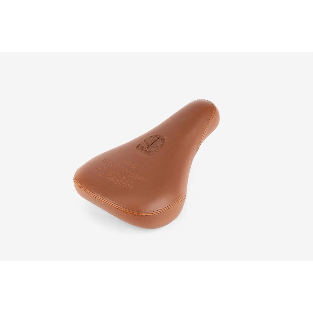 The Wethepeople Team Pivotal Fat Seat is a brown leather BMX seat featuring embossed text and logo, displayed on a plain white background.