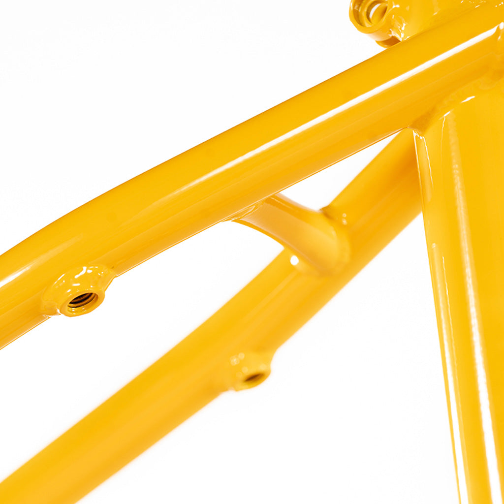 A Colony Enishi Flatland frame (Kio Hayakawa Signature), stands out with its yellow hue against a pristine white background.