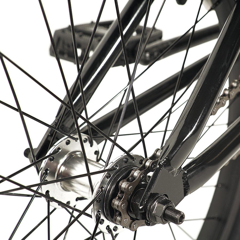 Close-up view of the Division Blitzer 20 Inch Bike's rear wheel hub, showcasing the spokes, chain, and part of the hi-tensile frame.