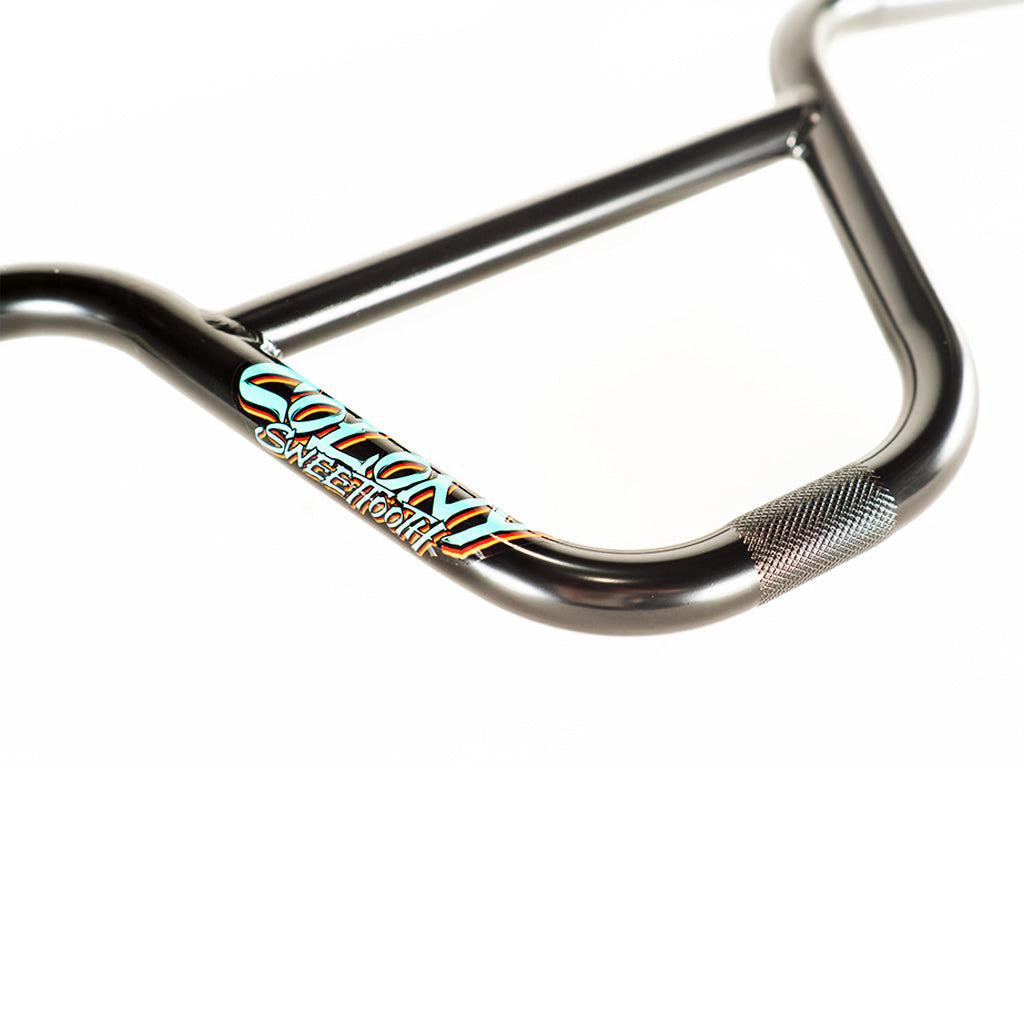 A high-performance Colony Sweet Tooth Junior Bars handlebar with a black handlebar and an orange logo on it.