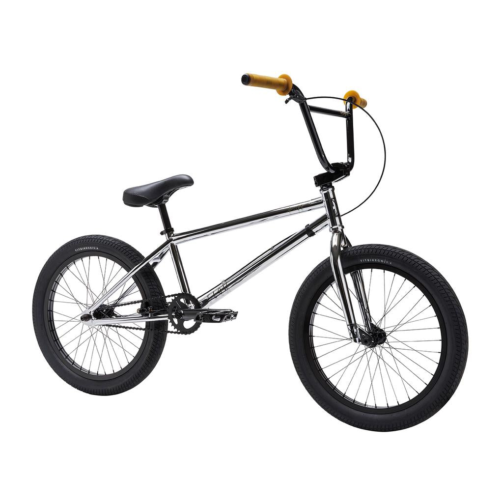 A Fit Bike Co Flow 20 Inch Bike with a chrome frame, black seat, black tires, and yellow handlebar grips is shown on a white background.