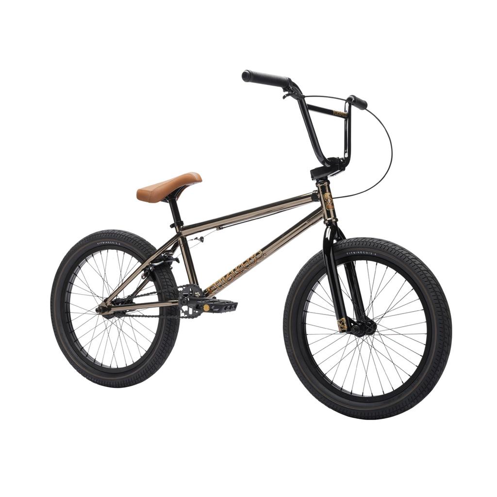 The Fit Bike Co Series One Bike is shown in black with a Cro-Mo frame, brown seat, thick tires, and a straight handlebar against a white background.