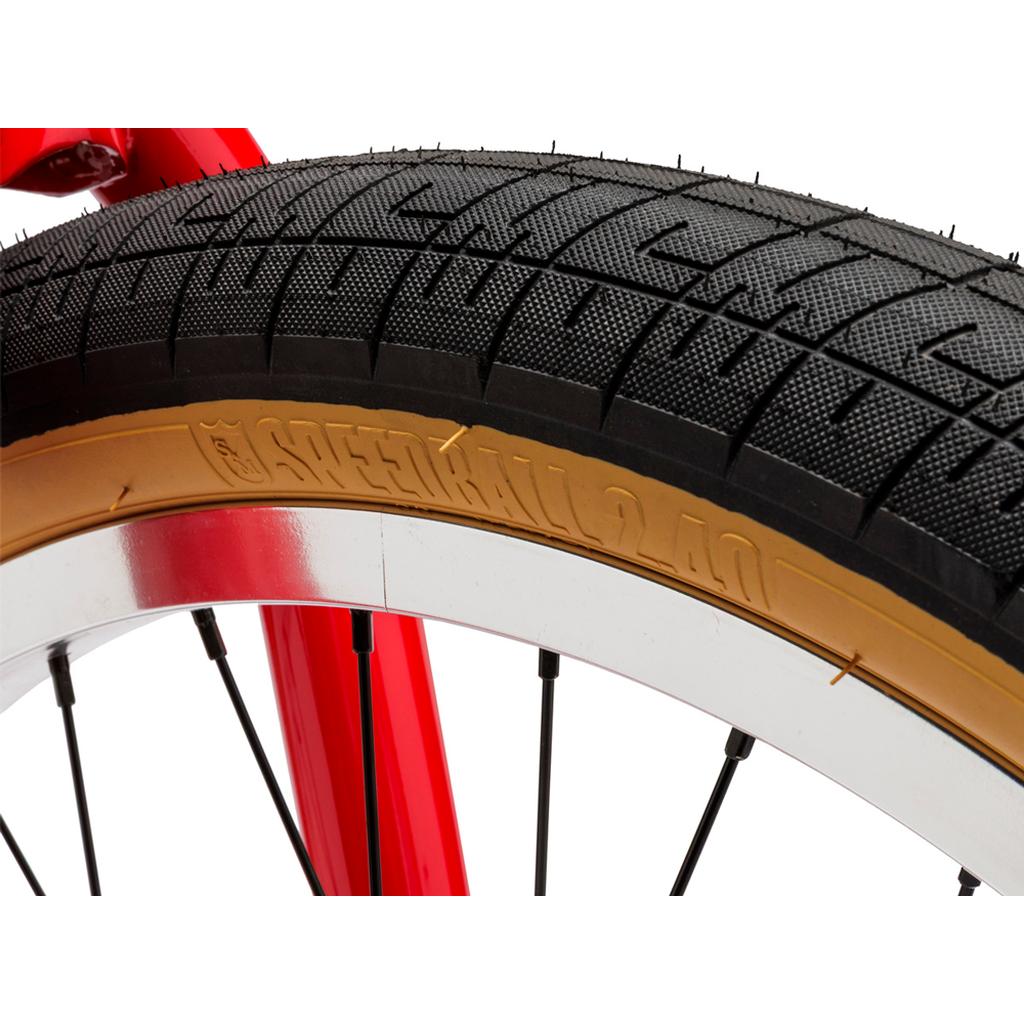 Close-up of a Fit Bike Co Series 22 Inch Bike wheel with a black tire labeled "SPEEDBALL 2.40" in gold, silver rim, and red frame, showcasing the signature 22 inch BMX design.