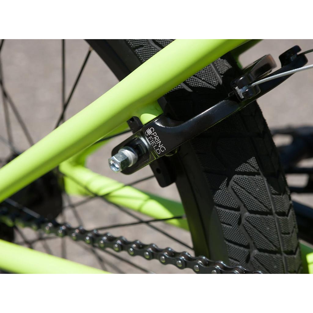 Close-up of the Sunday Blueprint 20 inch Bike's rear wheel, highlighting the tire, chain, and black Springfield brake caliper mounted on its neon green frame—ideal details for anyone looking for a dependable beginner BMX bike built with trusted Odyssey components.