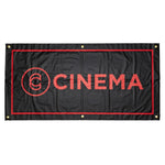 The Cinema Hanging Wall Banner features heavy-duty vinyl, a black background with red border, bold "CINEMA" lettering, and a circular logo on the left. Four metal grommets in the corners make it perfect for stylish room decor.