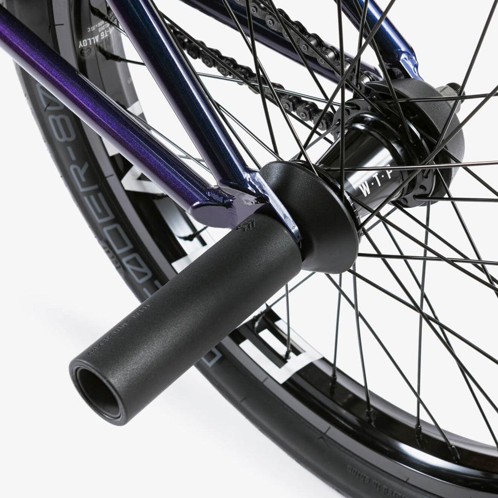 A close up of a Wethepeople Battleship 20 Inch BMX bike wheel with a purple handlebar.