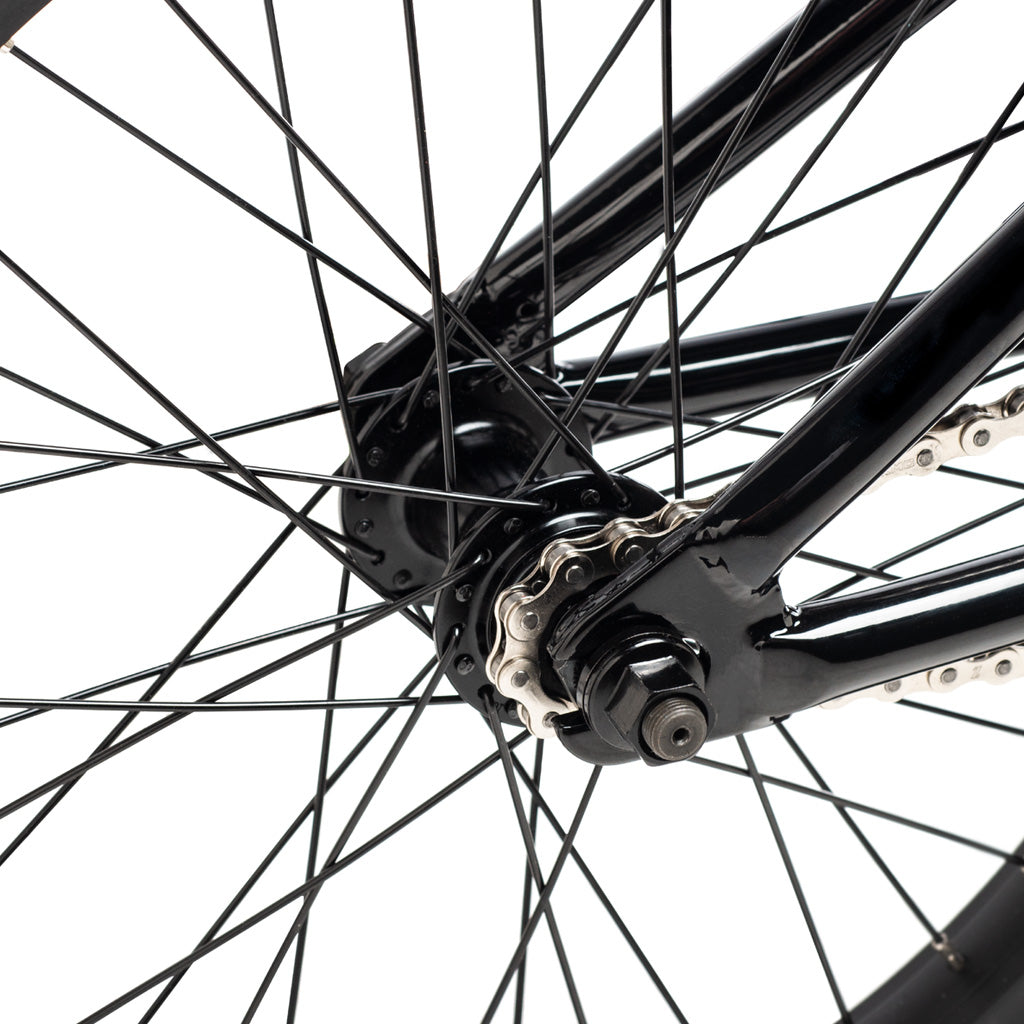 A close up of a black BMX wheel featuring the DK Aura 18 Inch Bike, on a white background.