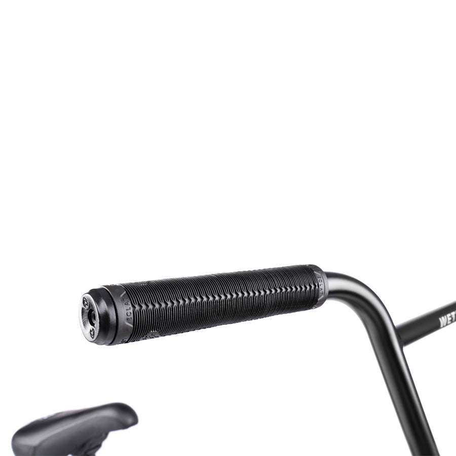A close up of a black handlebar on a Wethepeople Trust 20 Inch Cassette Bike.