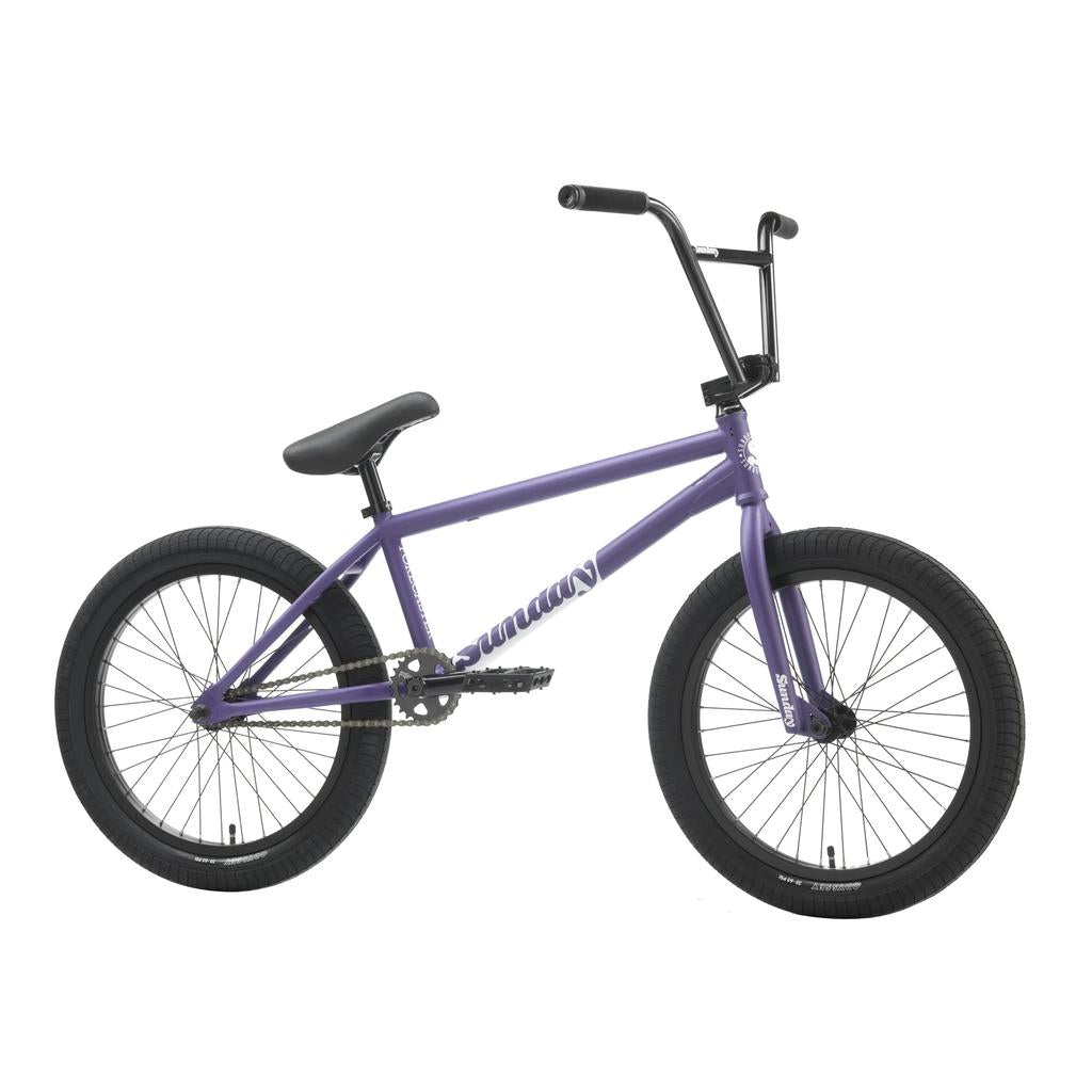 The Sunday Forecaster 20 Inch Bike is shown in profile on a white background, featuring a purple frame, sturdy chromoly build, and black handlebars, seat, and tires.