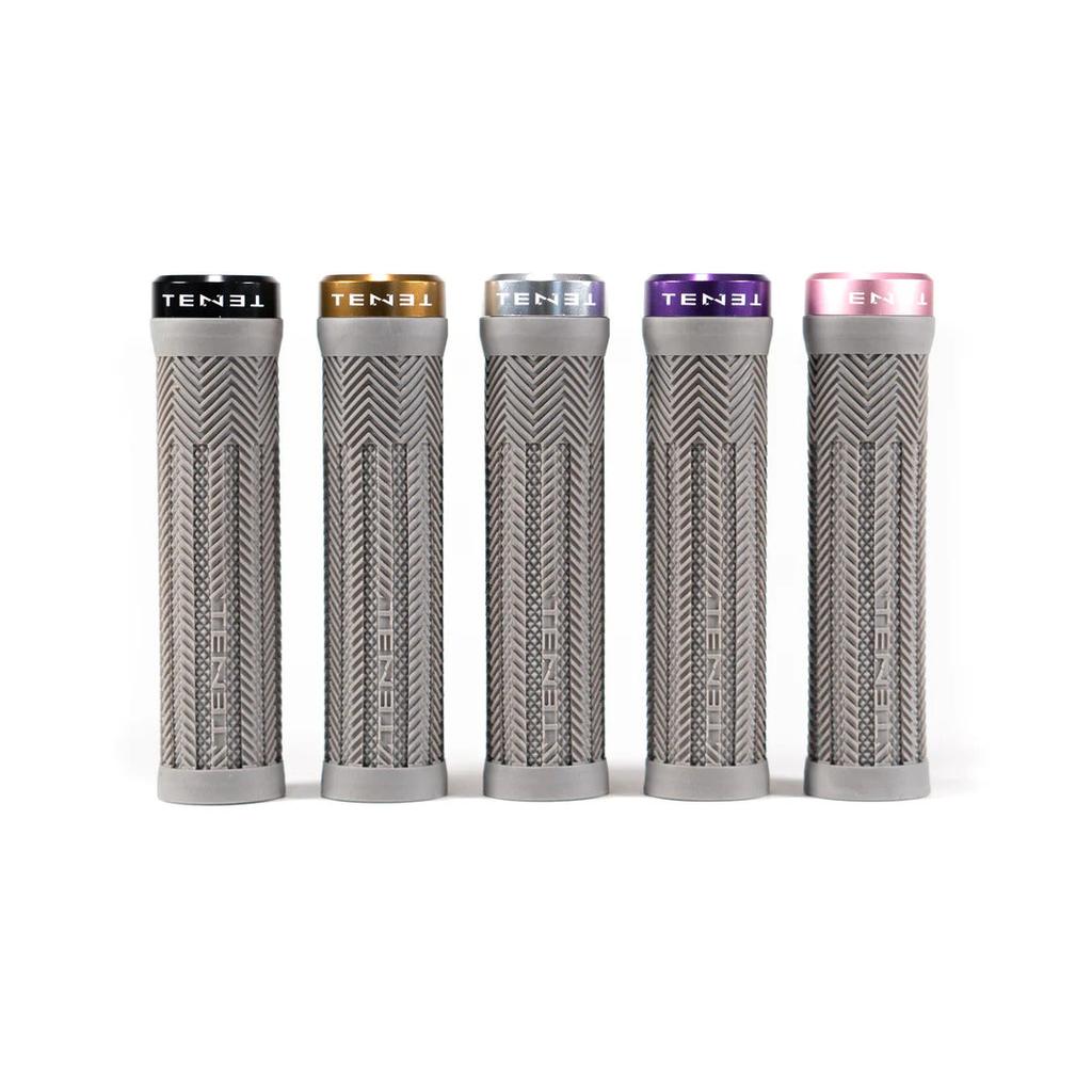 Introducing the Tenet Components - Icon Grip: a set of five grey, cylindrical mountain bike grips featuring textured patterns and topped with individual colored caps—black, gold, silver, purple, and pink. These lock-on grips are crafted from extra soft rubber to deliver superior comfort and control on every ride.