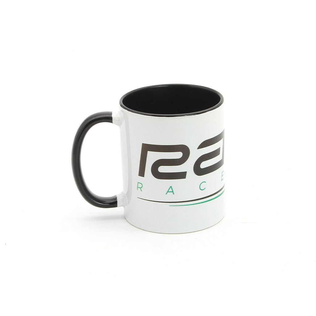 The Radio Raceline Coffee Mug is a white ceramic mug with a black handle and rim, featuring partial text and a green underline design on a plain white background.
