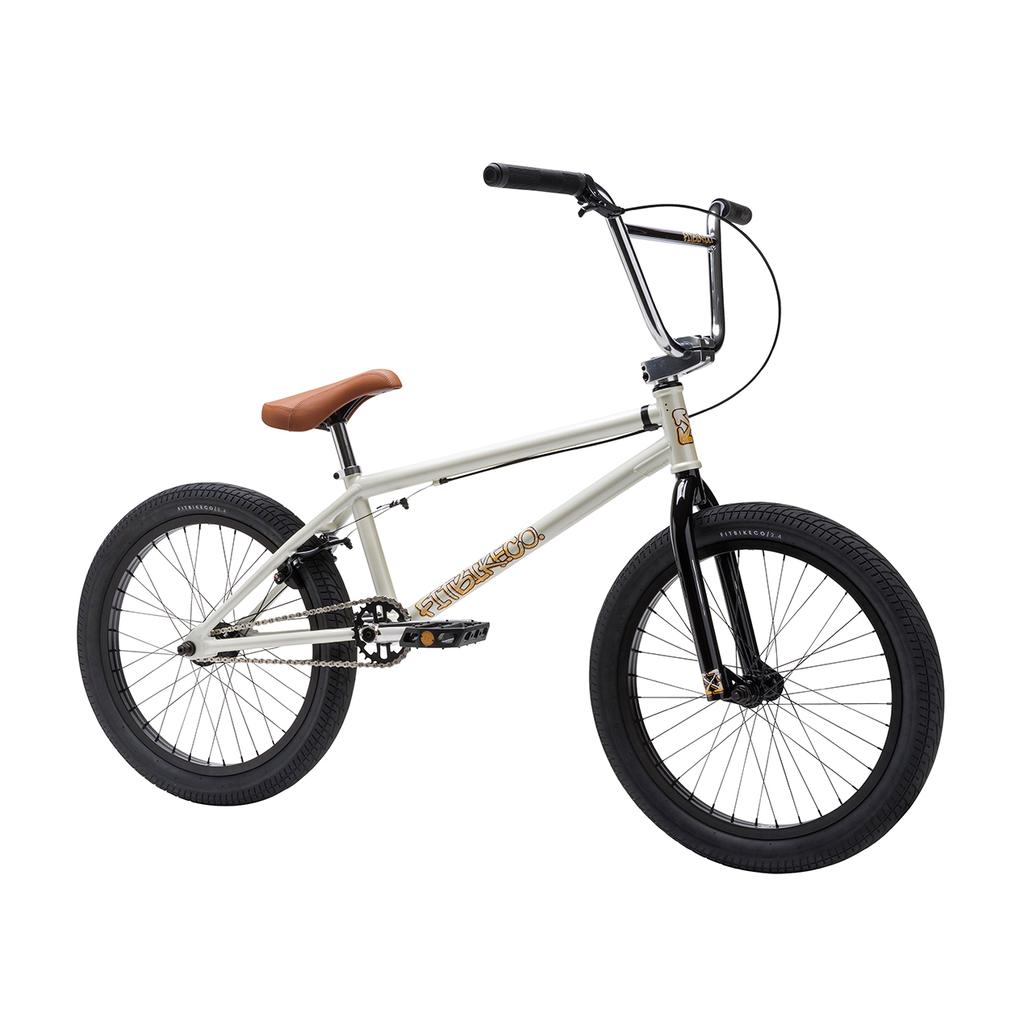 The Fit Bike Co Series One Bike, featuring a Cro-Mo frame with a white finish, black handlebars and wheels, and a brown saddle, is displayed against a plain white background.