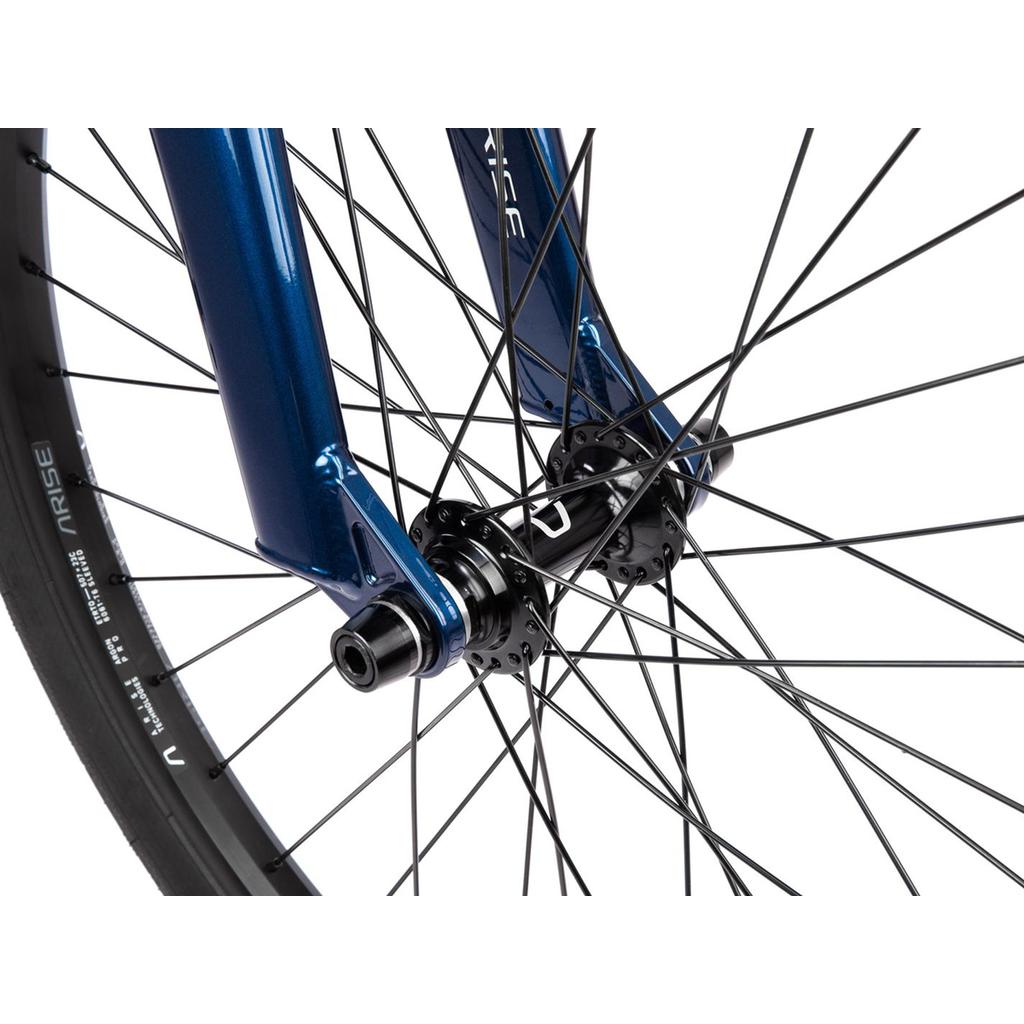 Close-up of the Radio Raceline Quartz Pro Disc 24 Inch Bike’s front wheel featuring black spokes, a blue fork, and a black hub with visible axle ends, showcasing its race-ready geometry.