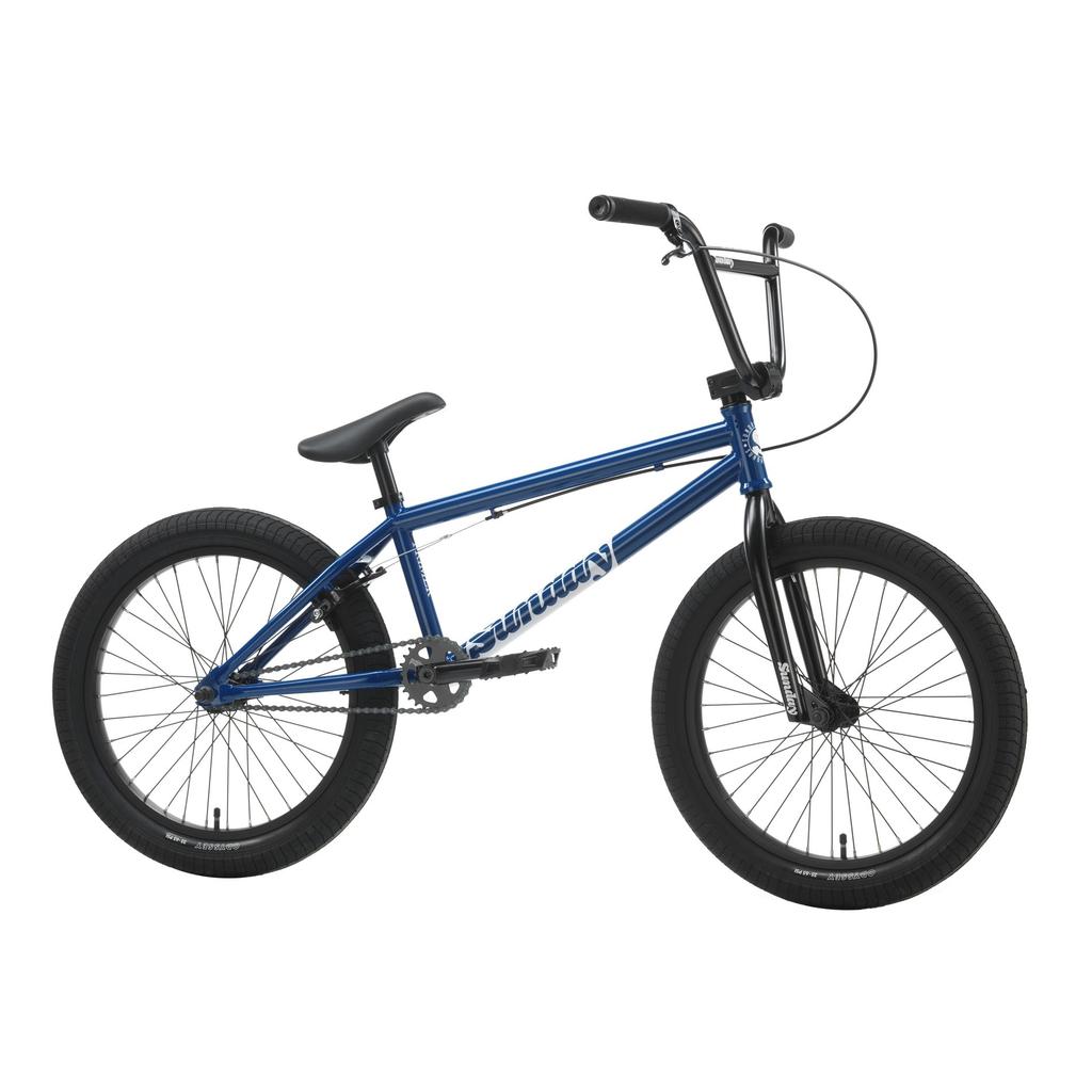 The Sunday Primer 20 Inch Bike is a blue BMX with black tires, black seat, and straight handlebar. Shown from the side against a white background, it features an Odyssey Springfield brake system for reliable performance.
