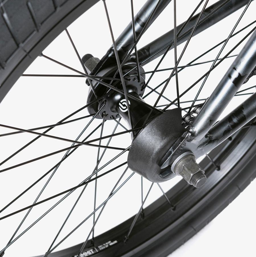 Close-up of a Wethepeople Justice 20 Inch Bike rear wheel showing the spokes, axle nuts, and part of the tire and hub against a white background.