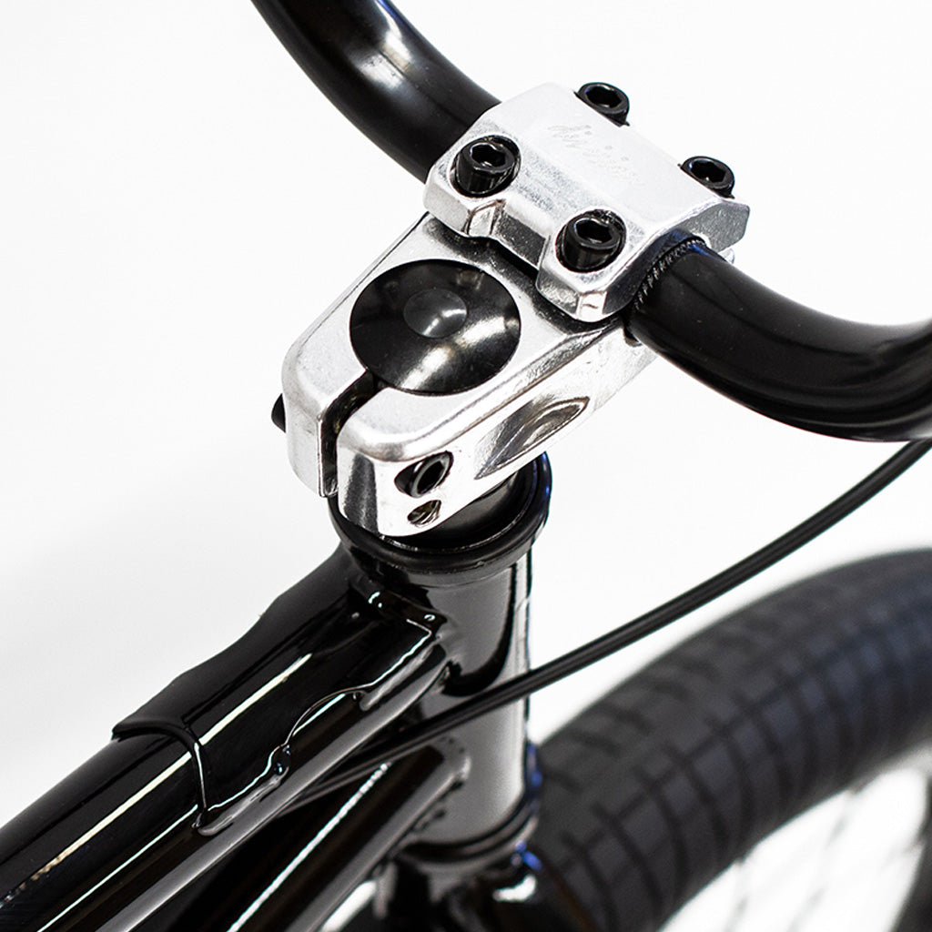 A close up of the handlebar on a black Division Reark 20 Inch Bike.