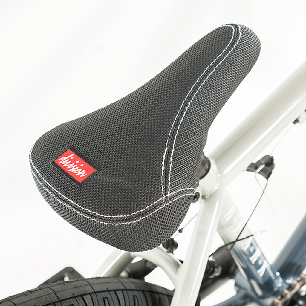 A close up of a bike seat with a Division Reark 20 Inch Bike logo on it.
