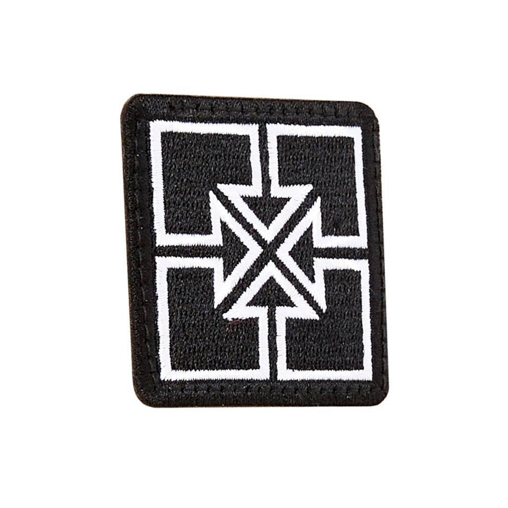 The Fit Bike Co Key Embroided Patch is a black patch with a white geometric cross and triangle design at the center, finished with a sleek satin border.