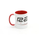 The Radio Raceline Coffee Mug is a 12oz white ceramic mug with a red interior and handle, featuring black and red text and design. Shown on a white background, it's perfect for fans of radio or unique track mugs.