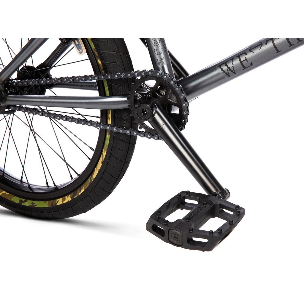 Close-up of the Wethepeople Arcade 20 Inch Bike drivetrain, showing the sprocket, chain, and black plastic pedal.