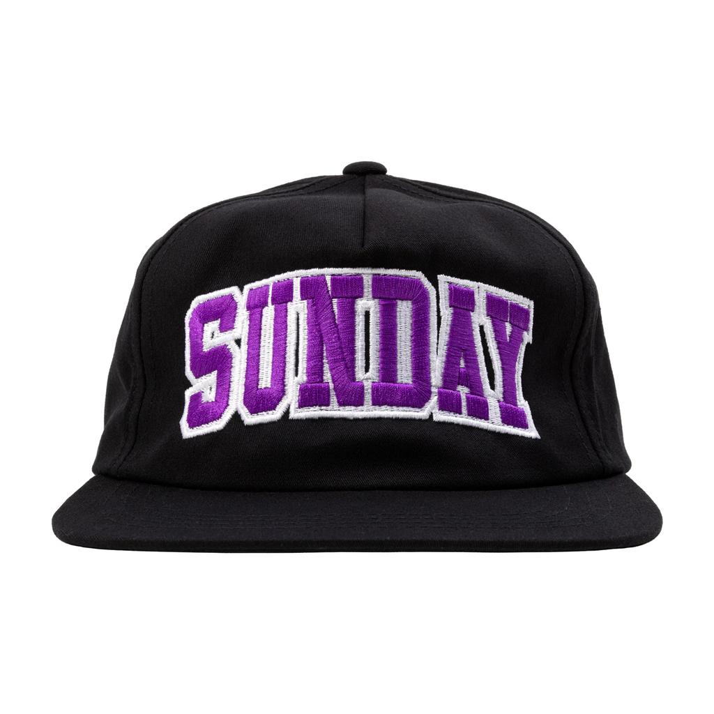 The Sunday Blockhead Cap is a stylish black hat featuring “SUNDAY” embroidered in bold purple and white letters on the front.
