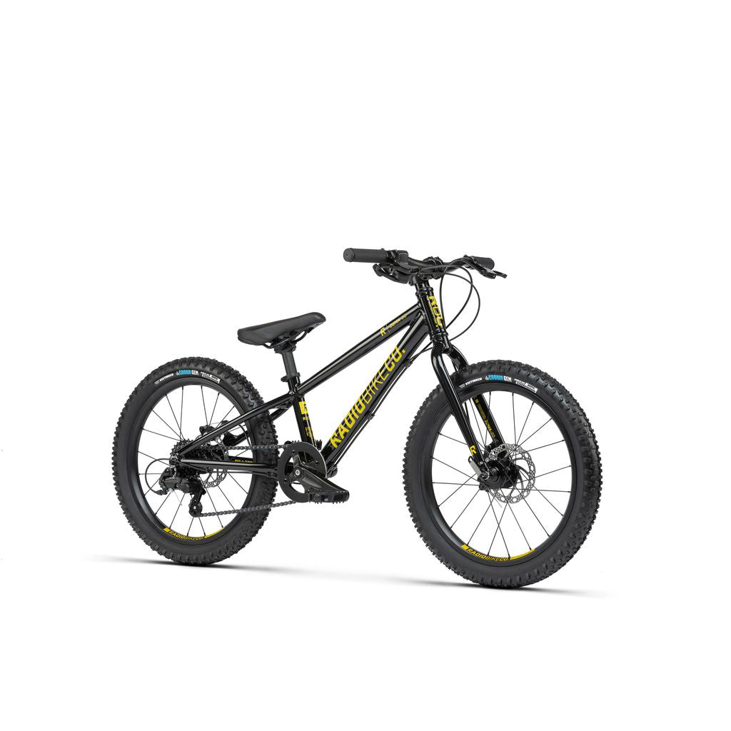 A black children's mountain bike with yellow and blue accents, featuring wide tires, front suspension, and disc brakes. This lightweight MTB bike from the Radio 20 Inch Zuma Bike range is designed for young adventurers. The frame reads "Woom OFF.