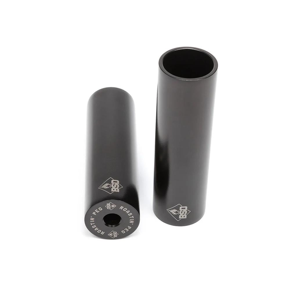 Two black BSD Roastin Peg BMX grind pegs made from durable 4140 chromoly, each featuring white logo and text markings, are shown upright and lying down against a white background.