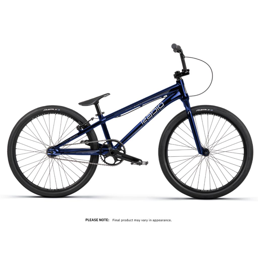 The Radio Raceline Quartz Pro Disc 24 Inch Bike, shown from the side against a white background, features blue paint, black tires, a straight handlebar, slim seat, and a durable hydroformed 6061-T6 alloy frame.