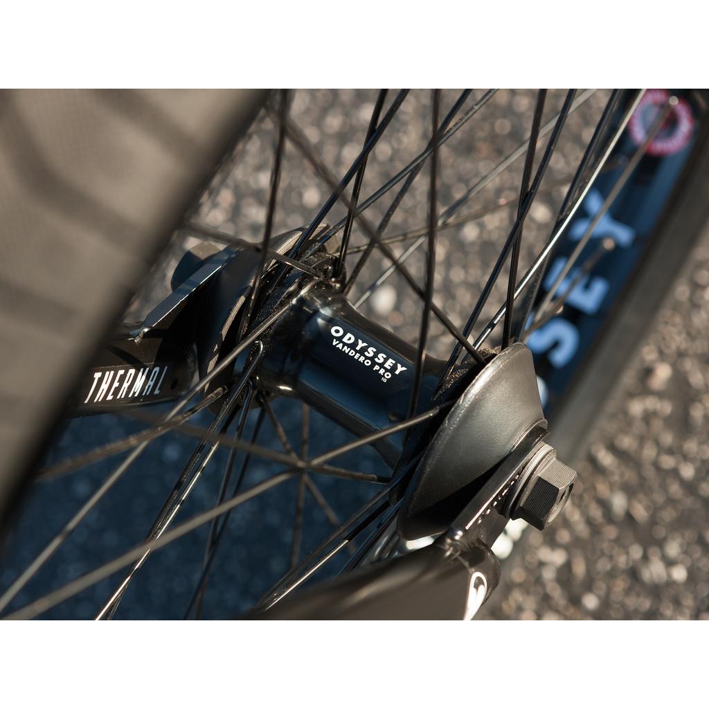 Close-up of the Sunday Sound Wave Special 20 Inch Bike (2023), featuring detailed spokes and axle against textured asphalt—a top pick for BMX enthusiasts.