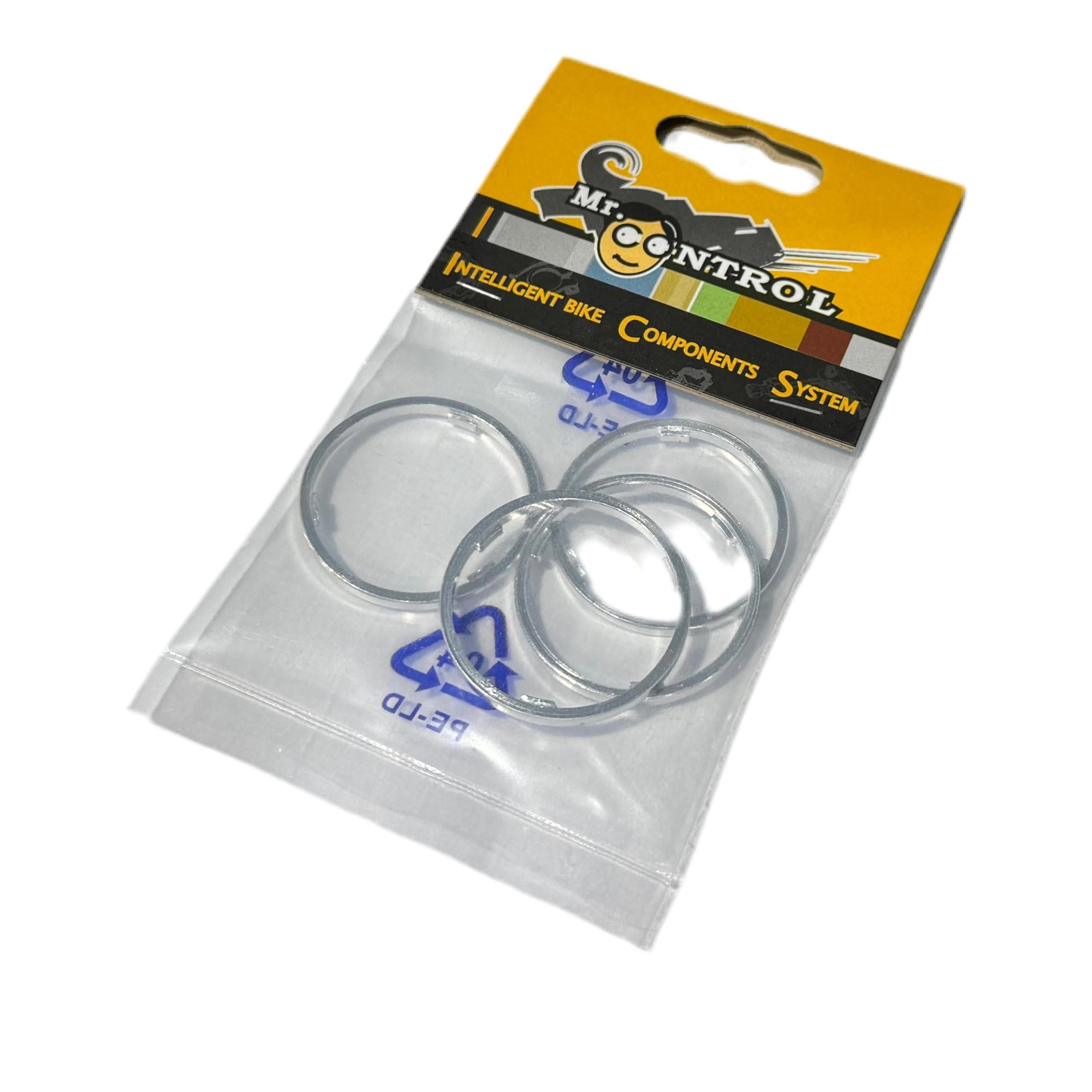 A retail package labeled "Cassette Body Spacer Shimano (4 Pack)" contains four silver cassette body spacers in a clear plastic bag.