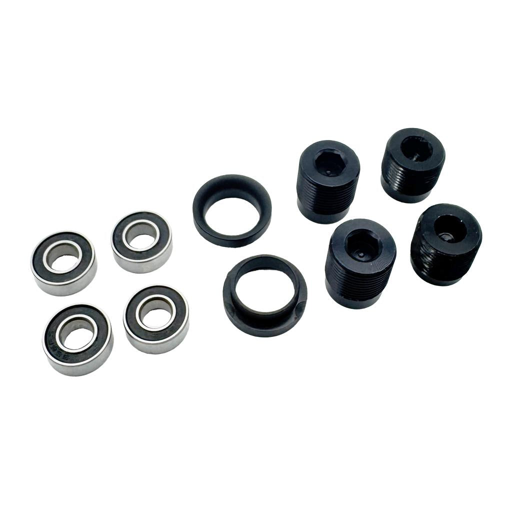 The Eclat Surge XL Pedal Bearing Set includes four metal ball bearings, two black rubber rings, and four black threaded cylinders—perfect as a bearings kit or replacement parts for the Surge XL.