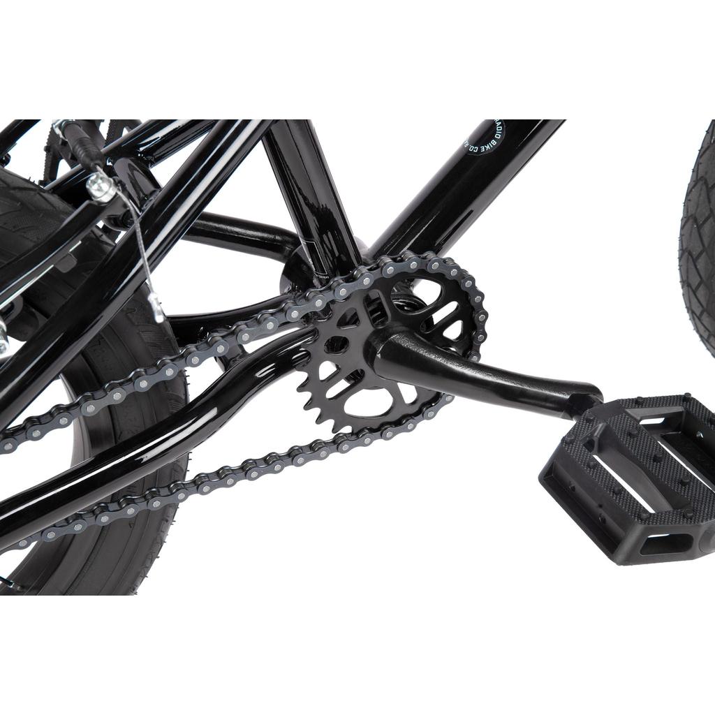 Close-up of a Radio Revo 14 Inch bike crankset, chainring, chain, and pedal on a black frame—the ideal detail shot for anyone’s first bike.