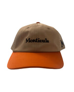 The Monticule Vapor Strap Back Hat features a tan and orange design with "Monticule" embroidered in black on the front. This breathable hat is stylish and comfortable, perfect for everyday wear.