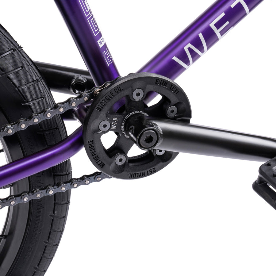 A purple Wethepeople Trust 20 Inch Freecoaster bike with a chain attached to it.