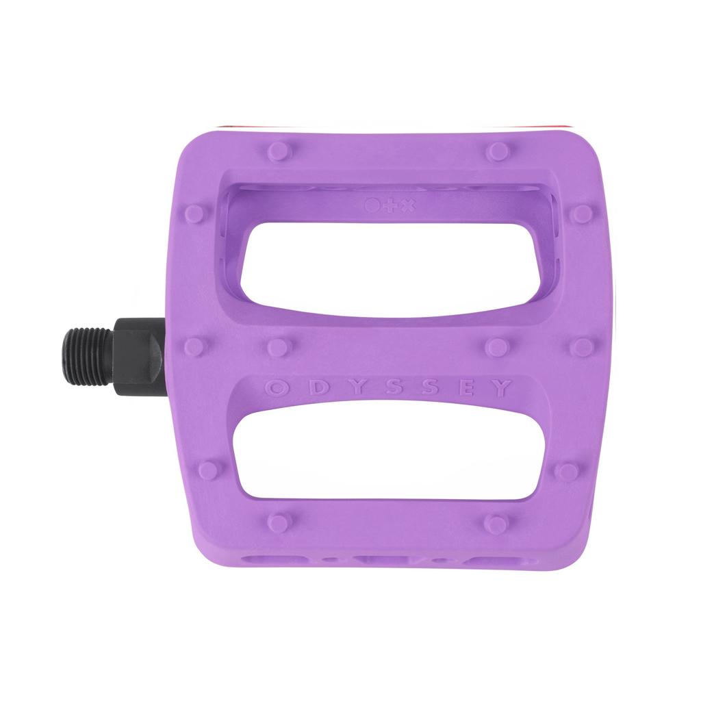 A purple Odyssey Twisted PC Pro Pedal features a rectangular shape, two cutouts, durable nylon composite body, oversized grip pins, and a black left threaded spindle.