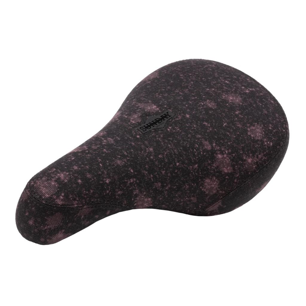 The Sunday Bleached Pivotal Seat (Brett Silva Signature) is a black and pink speckled BMX seat with "SUBROSA" on top, featuring a pivotal design inspired by pro rider Brett Silva.