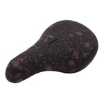 The Sunday Bleached Pivotal Seat (Brett Silva Signature) is a black and pink speckled BMX seat with "SUBROSA" on top, featuring a pivotal design inspired by pro rider Brett Silva.