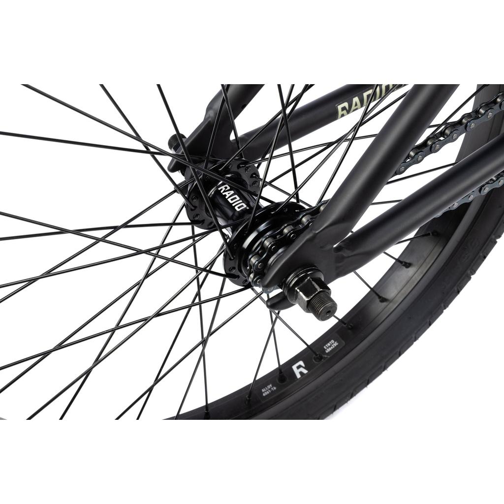 Close-up of the Radio Evol XL 20 Inch Bike's rear wheel, highlighting the spokes, hub, axle, chain, and black frame details against a white background.