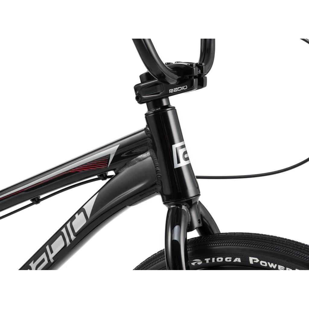 Close-up of a black Radio Helium Pro 24 Inch Cruiser Bike frame focusing on the front fork, handlebars, and part of the front tire labeled "TIOGA POWERBLOCK.
