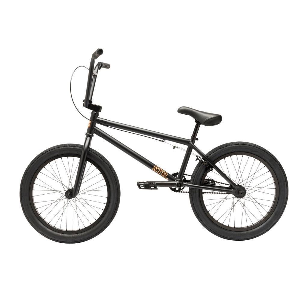 A side view of the Fit Bike Co STR 20 Inch Bike—a black BMX with thick tires, straight handlebars, and a compact frame, designed for modern street riding.