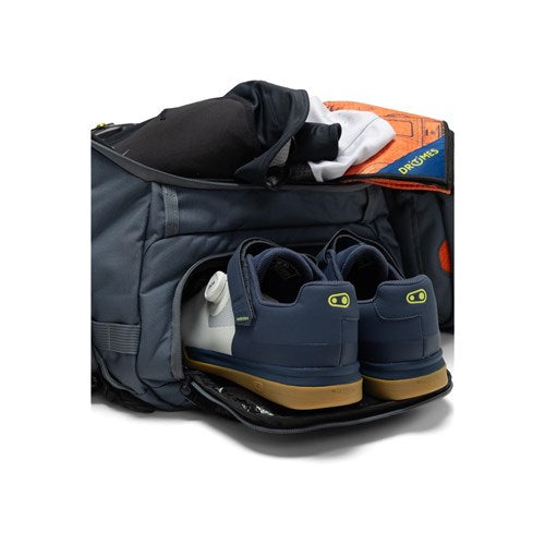 An Albek Skytrail 51 Gear Bag with an open compartment displays sneakers and clothes inside, making it the ideal choice for your next adventure travel bag.