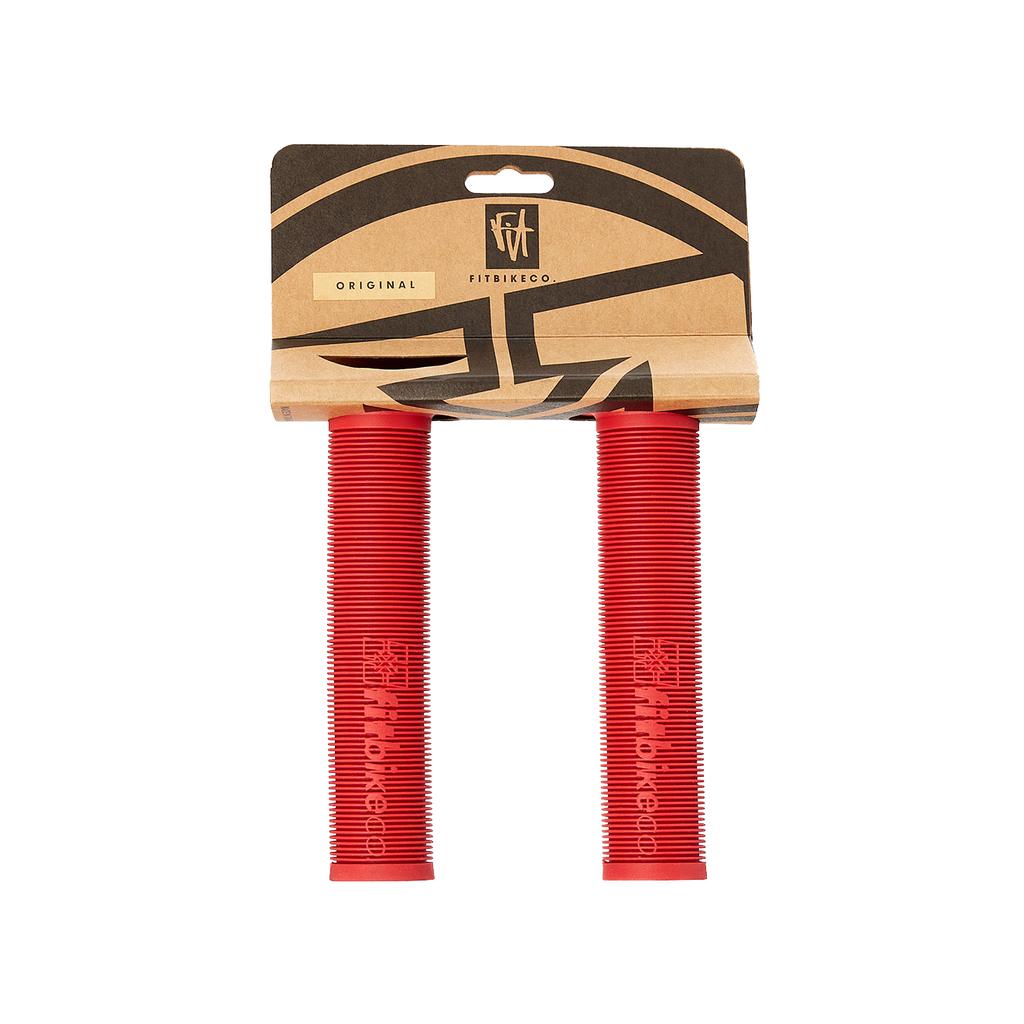 A pair of red Fit Bike Co OG Grips with a ribbed, mushroom-finned surface, in retail packaging labeled "FITBIKECO Original.