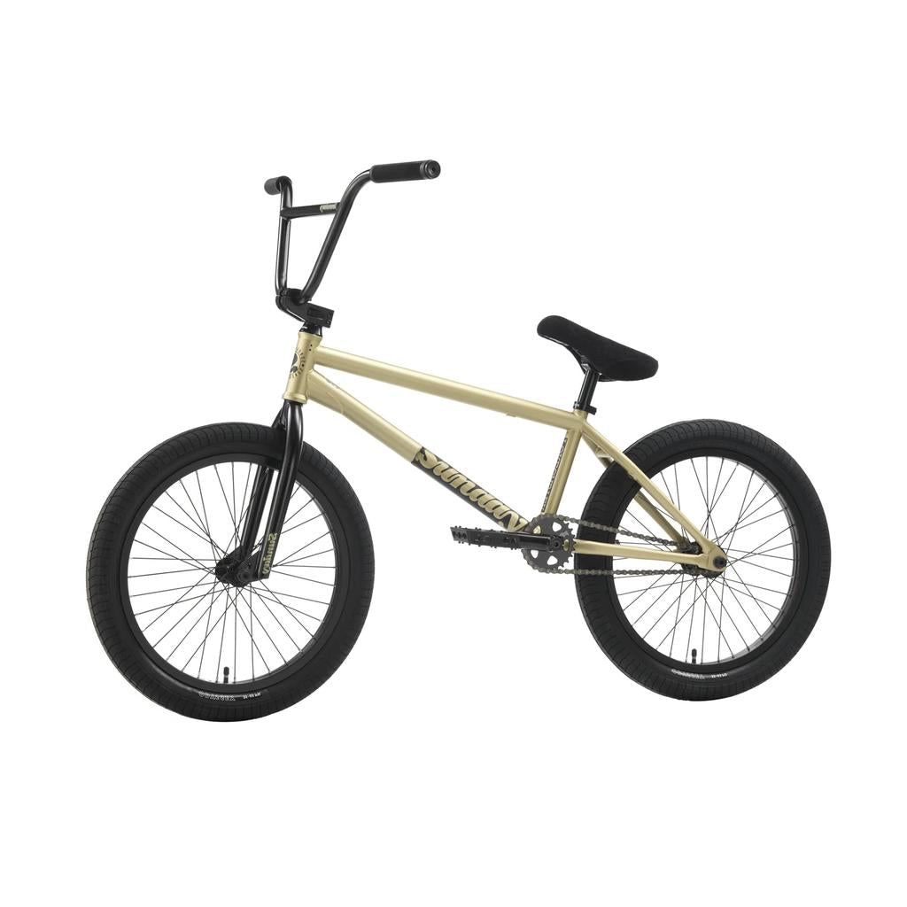 The Sunday Forecaster 20 Inch Bike (2025) / Broc Raiford is shown from the side against a white background, featuring a beige and black design, straight top tube, black handlebars, thick tires, and a full chromoly frame.