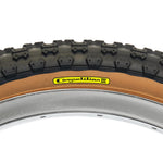 Close-up of a Tioga Comp 3 Skin Wall Tyre (20 Inch) featuring black tread, tan sidewall, and a yellow "Competition III" label mounted on a silver rim.
