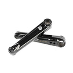 Two black Eclat Tibia XLT Cranks arms are crossed on a white background, highlighting their logo and sleek, lightweight design.