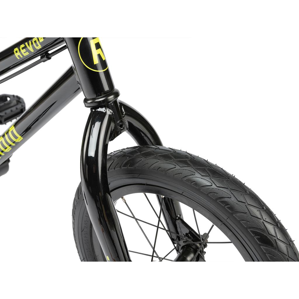 Close-up of the Radio Revo 14 Inch bike’s front wheel and fork, highlighting tread, spokes, and part of the frame with yellow graphics on a white background—ideal as a first bike.