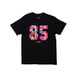 The Odyssey 85 Splatter T-Shirt features a bold "85" in colorful floral print on the chest with small yellow text beneath—an eye-catching standout from our splatter line.